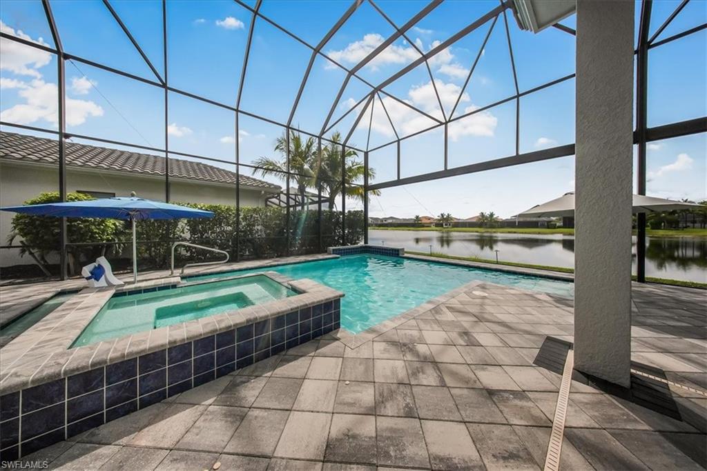 4616 Azalea Drive Naples, FL 34119 - Photo 32 of 44 View of pool featuring a water view, glass enclosure, a sunroom, a pool with connected hot tub, and a patio