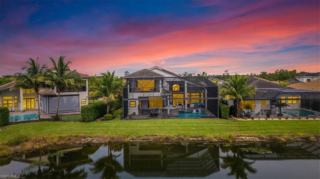4616 Azalea Drive Naples, FL 34119 - Photo 38 of 44 Back of house at dusk with a patio area, a water view, a sunroom, and an outdoor pool