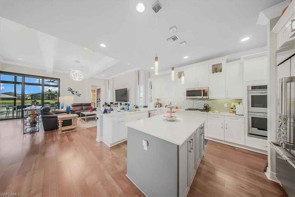 4616 Azalea Drive Naples, FL 34119 - Photo 44 of 44 Kitchen featuring open floor plan, decorative light fixtures, white cabinetry, a peninsula, and recessed lighting