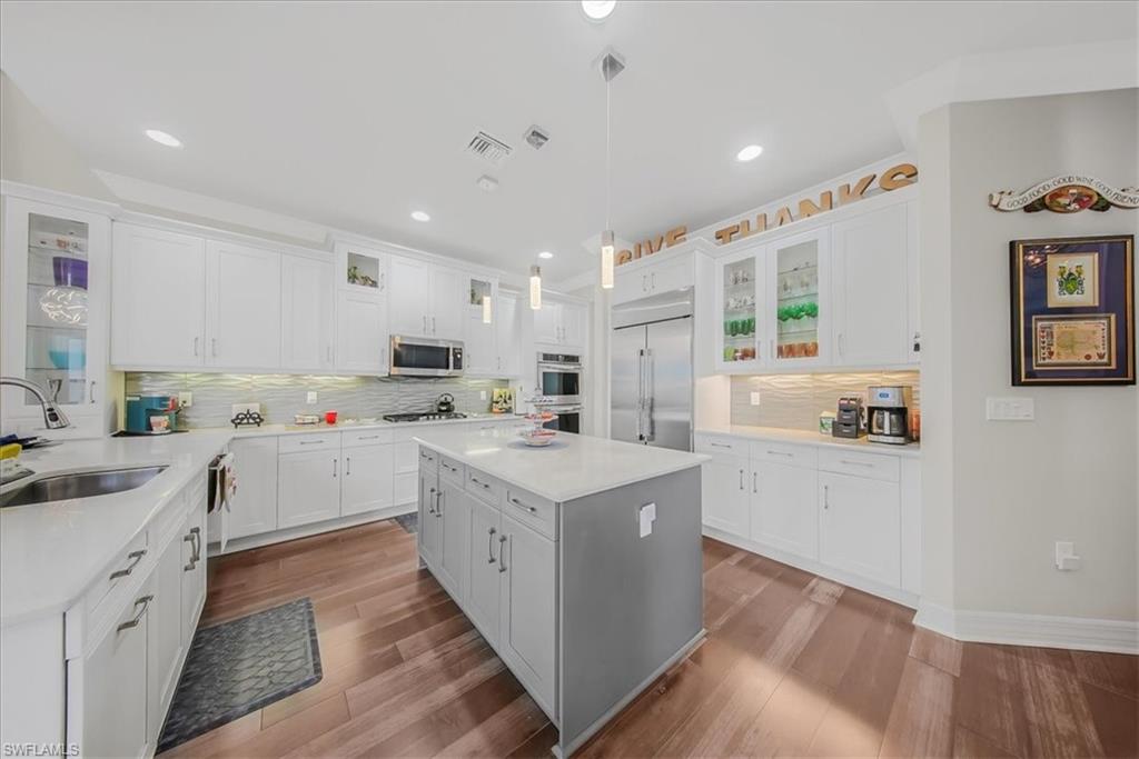 4616 Azalea Drive Naples, FL 34119 - Photo 7 of 44 Kitchen with glass insert cabinets, backsplash, white cabinetry, hanging light fixtures, and recessed lighting