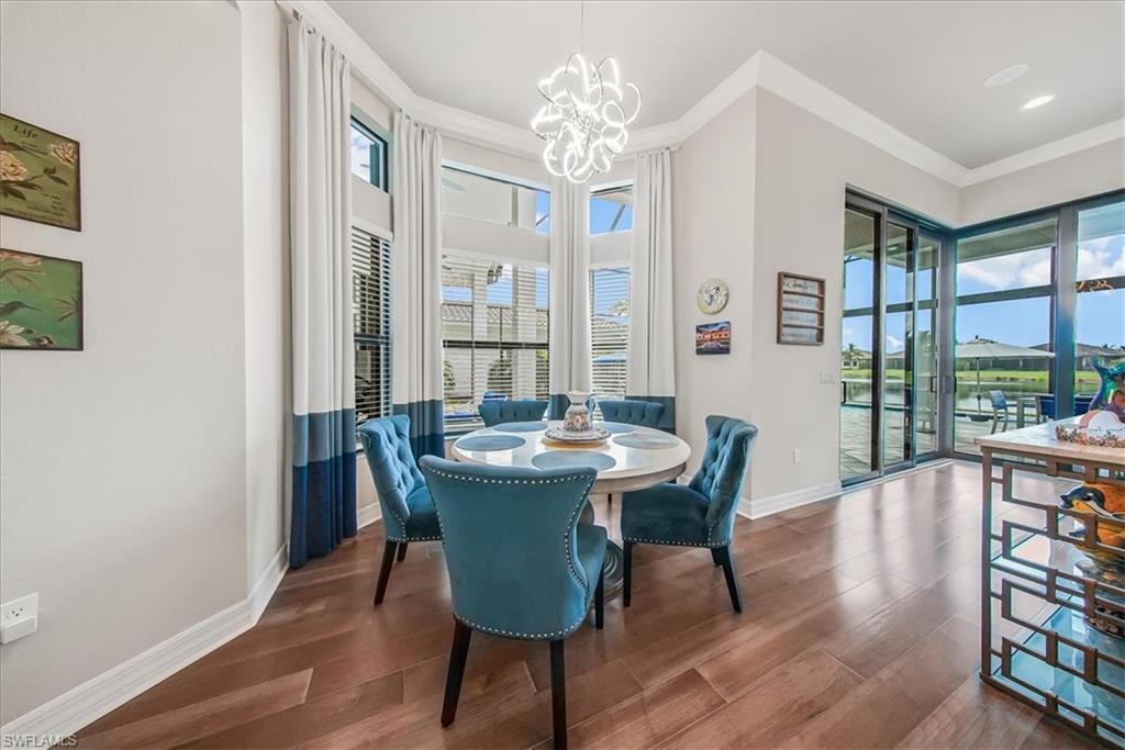 4616 Azalea Drive Naples, FL 34119 - Photo 8 of 44 Dining area featuring dark wood-style floors, ornamental molding, and a chandelier