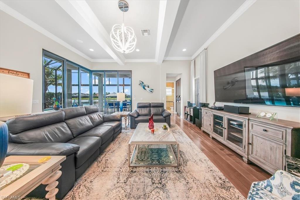4616 Azalea Drive Naples, FL 34119 - Photo 9 of 44 Living room featuring beam ceiling, light wood-type flooring, a chandelier, recessed lighting, and crown molding