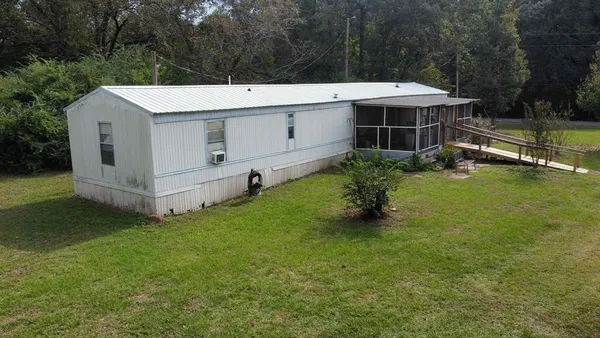 a view of a house with a yard and sitting area