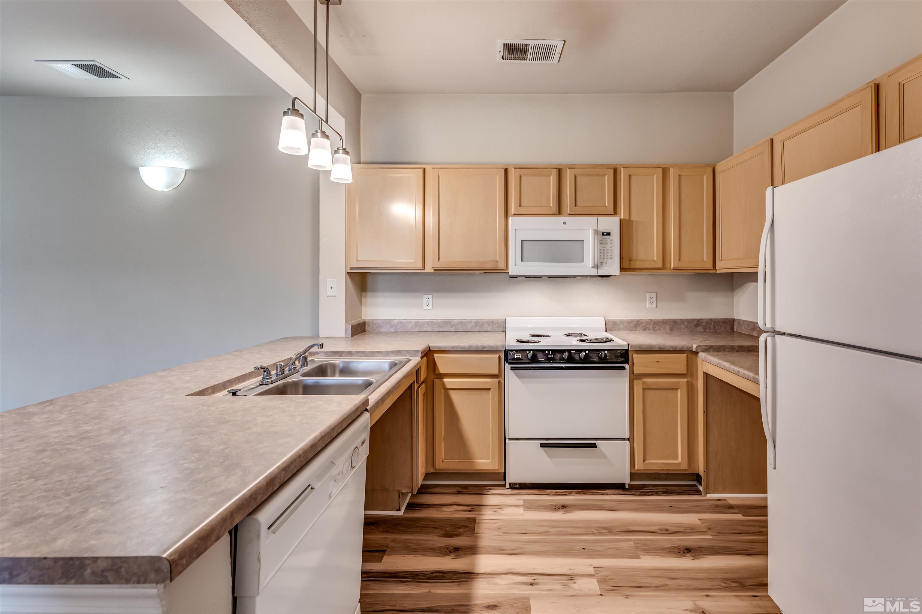 200 Talus Way, Unit 312 Reno, NV 89503 - Photo 11 of 33 a kitchen with a stove a sink and a refrigerator