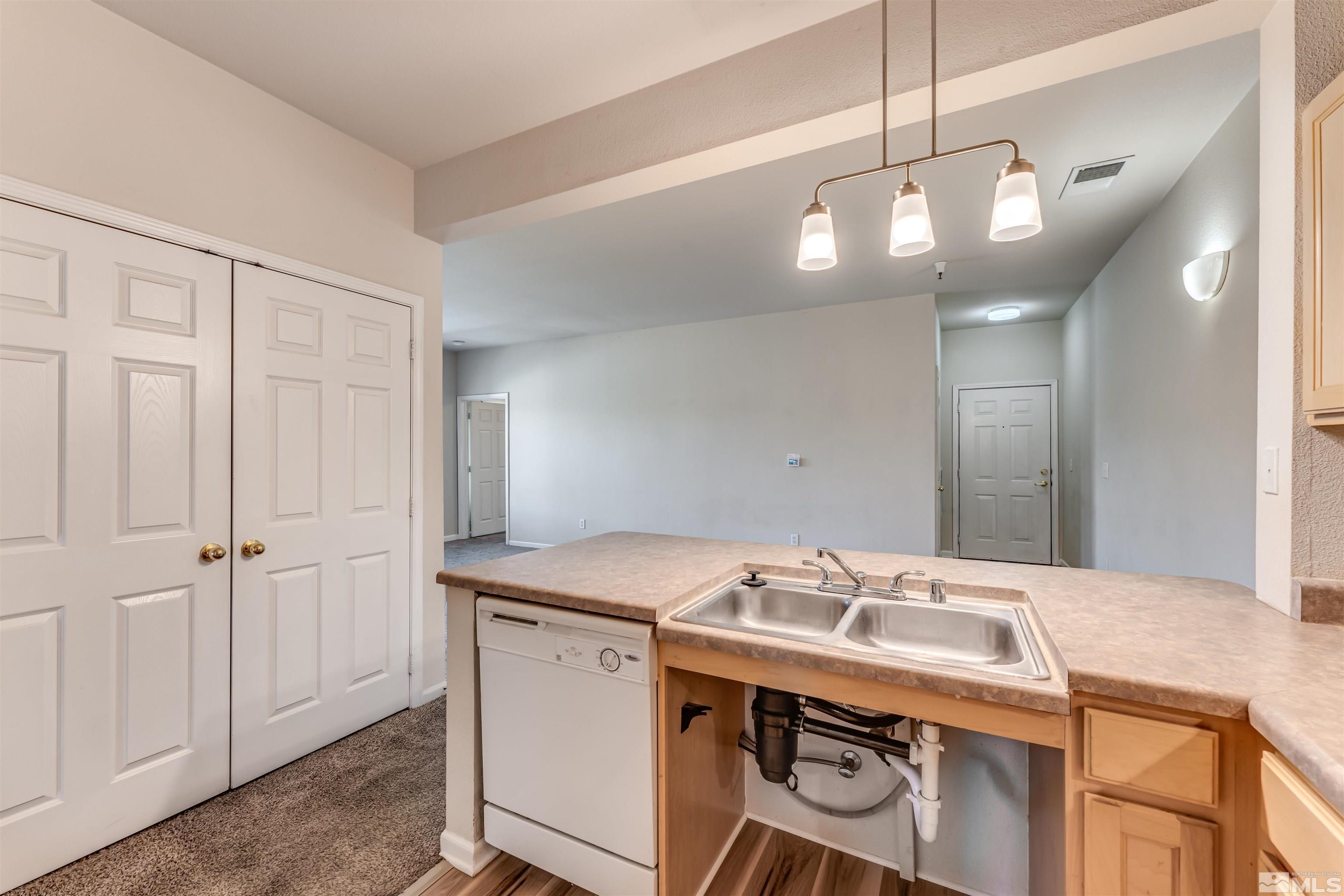 200 Talus Way, Unit 312 Reno, NV 89503 - Photo 13 of 33 a view of a kitchen island a sink a refrigerator and chandelier
