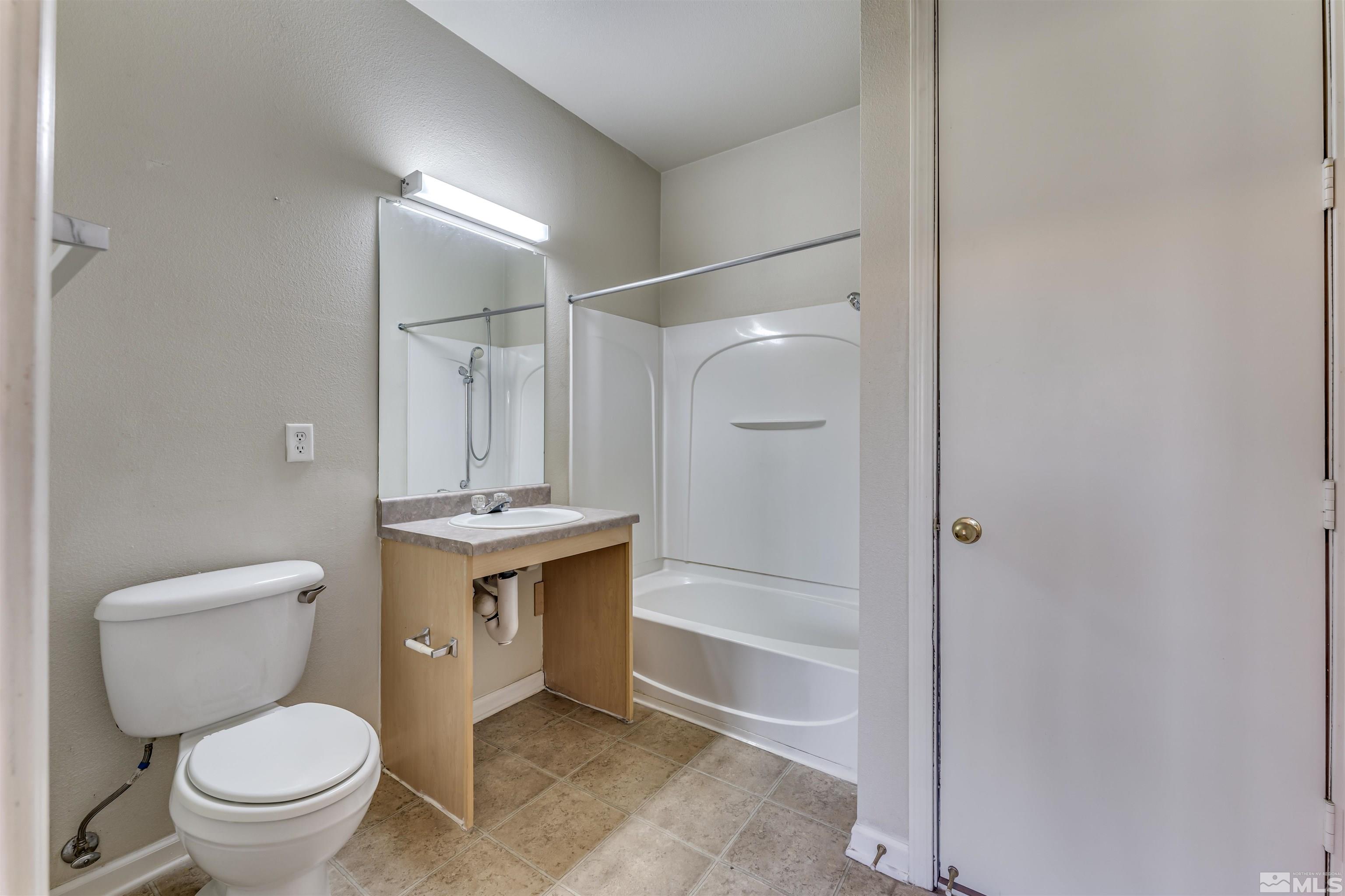 200 Talus Way, Unit 312 Reno, NV 89503 - Photo 22 of 33 a bathroom with a granite countertop toilet sink and shower