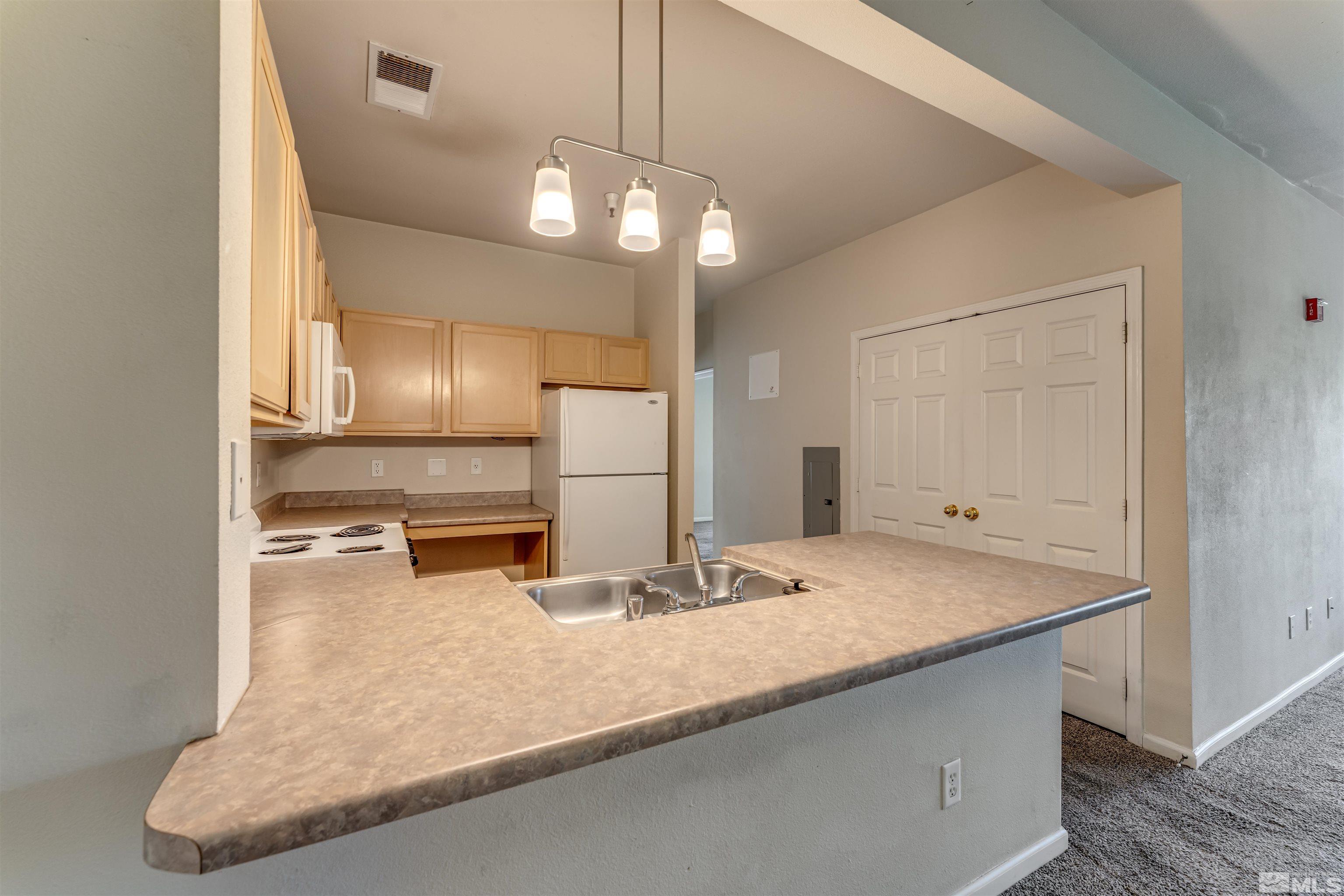 200 Talus Way, Unit 312 Reno, NV 89503 - Photo 8 of 33 a kitchen with kitchen island a counter top and a chandelier
