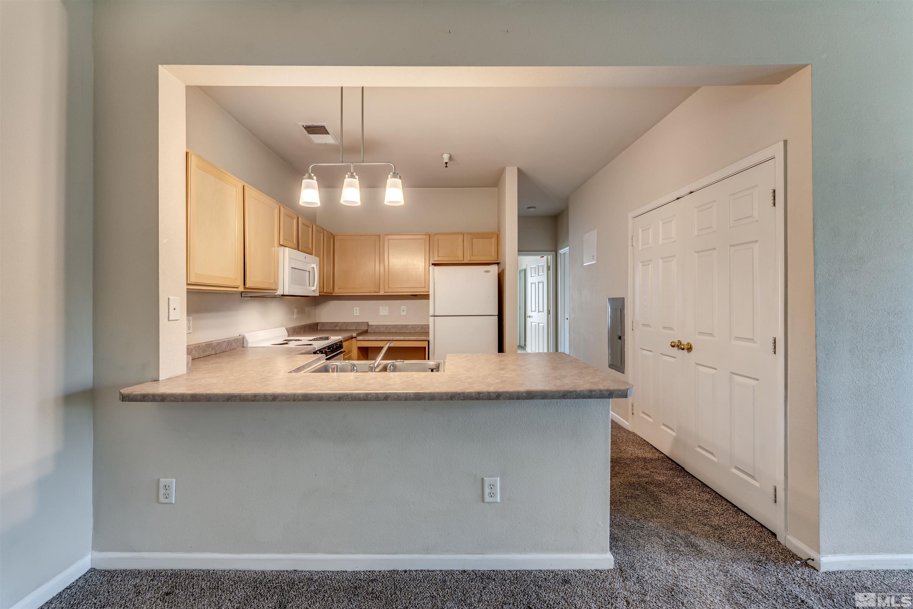 200 Talus Way, Unit 312 Reno, NV 89503 - Photo 9 of 33 a kitchen with kitchen island a sink a stove a refrigerator and cabinets