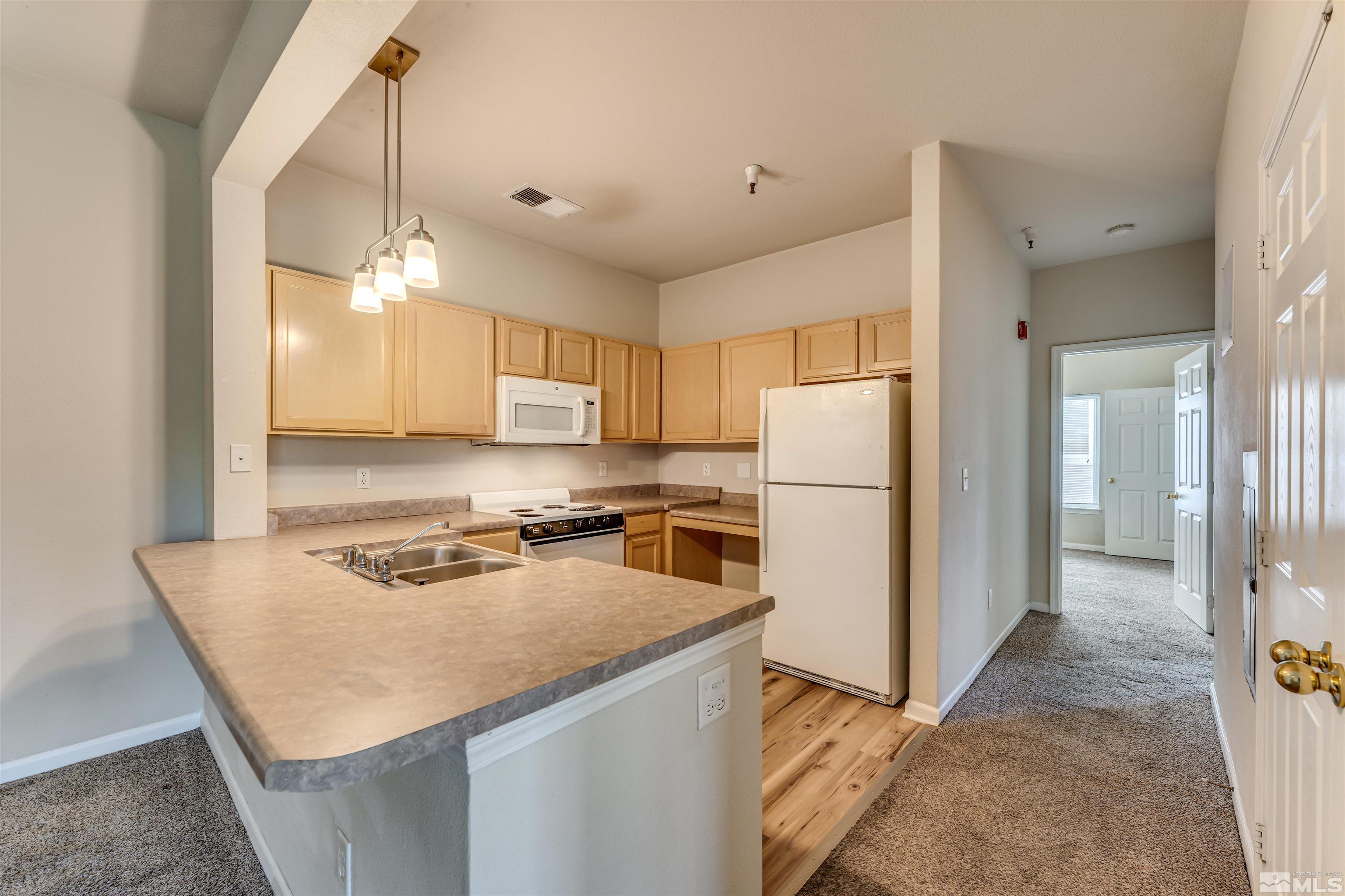 200 Talus Way, Unit 312 Reno, NV 89503 - Photo 10 of 33 a kitchen with a refrigerator a stove a sink and a refrigerator