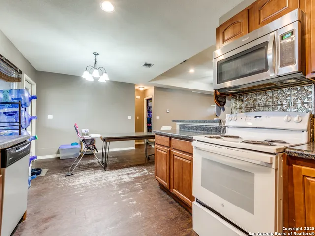 a kitchen with stainless steel appliances granite countertop a stove and cabinets