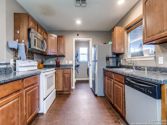 a kitchen with stainless steel appliances granite countertop a stove a sink dishwasher and a refrigerator