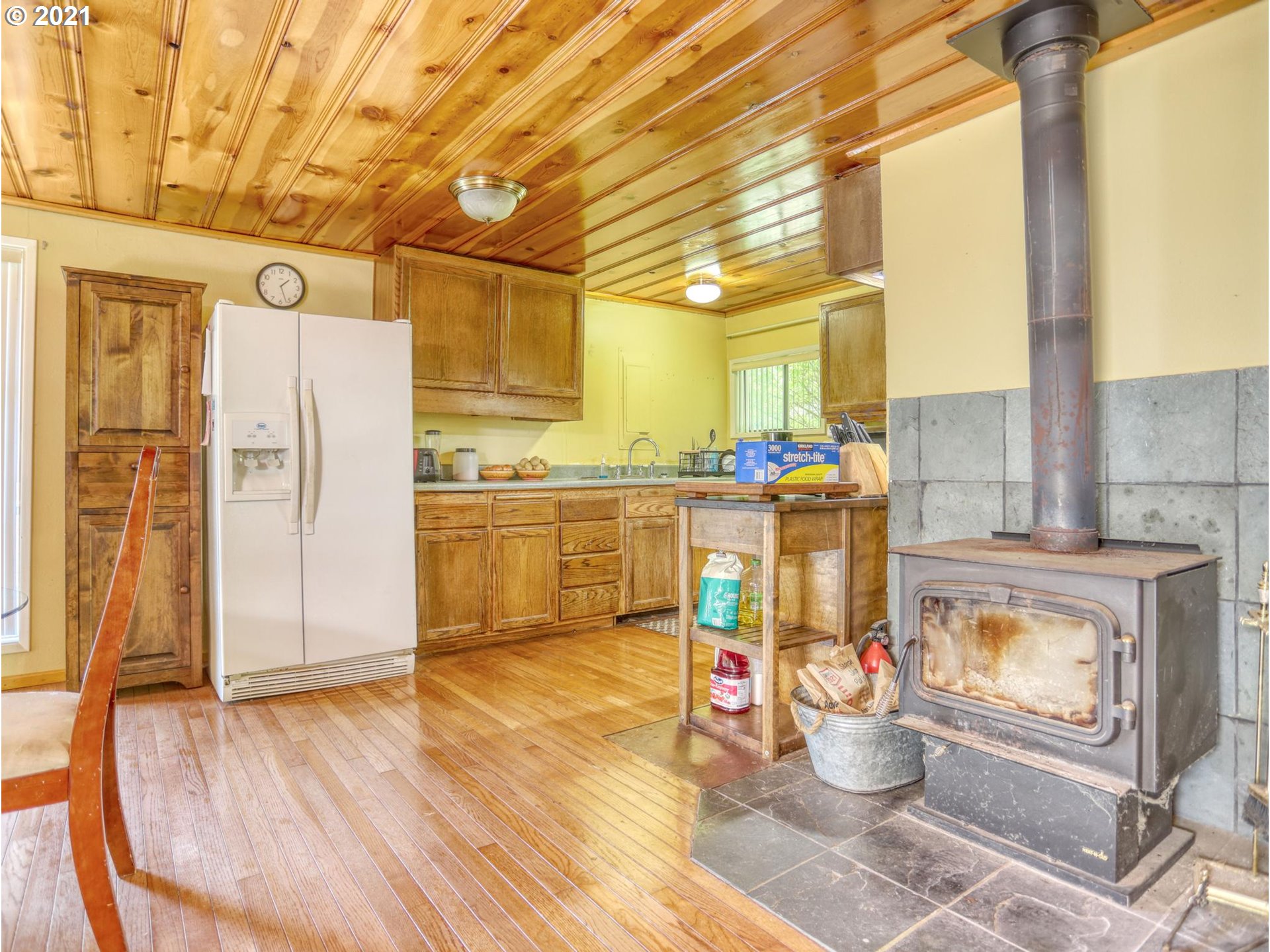 21070 Southeast Bornstedt Road Sandy, OR 97055 - Photo 6 of 31 a living room with stainless steel appliances kitchen island granite countertop a refrigerator a stove and white cabinets with wooden floor