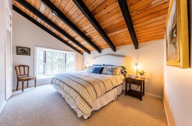 a bed sitting in a spacious bedroom next to a window