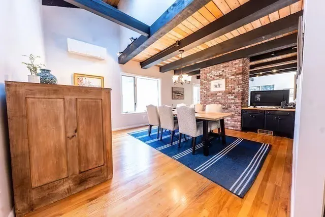 a living room with furniture a wooden floor and next to a window