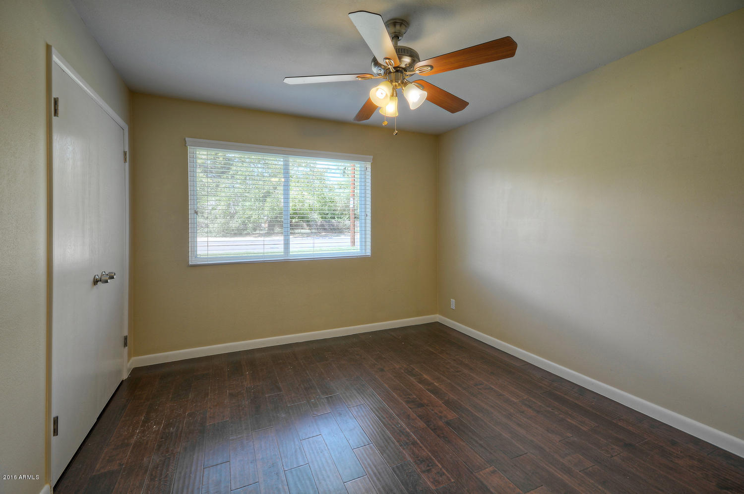 4831 East Osborn Road Phoenix, AZ 85018 - Photo 21 of 27 an empty room with wooden floor and windows