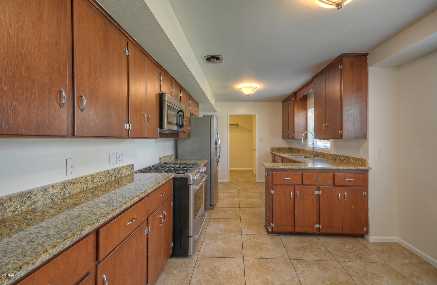4831 East Osborn Road Phoenix, AZ 85018 - Photo 8 of 27 a kitchen with stainless steel appliances granite countertop a stove a sink and a refrigerator
