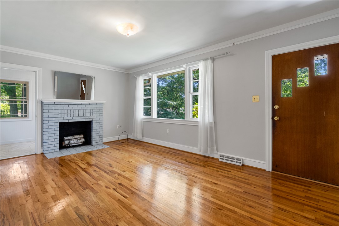 1509 869 Anderson, SC 29621 - Photo 5 of 45 Warm hardwood floors and a white-painted brick fireplace define this inviting living area.