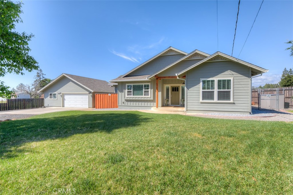 a view of a house with a big yard plants and large trees