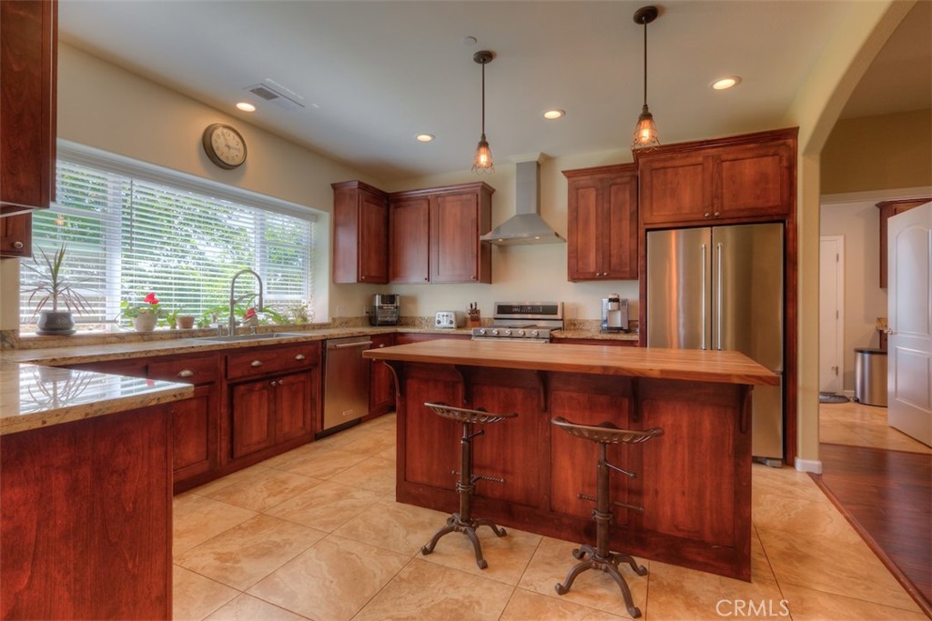 95 Sutter Road Paradise, CA 95969 - Photo 9 of 47 a kitchen with stainless steel appliances granite countertop wooden cabinets a stove a sink a dining table and chairs