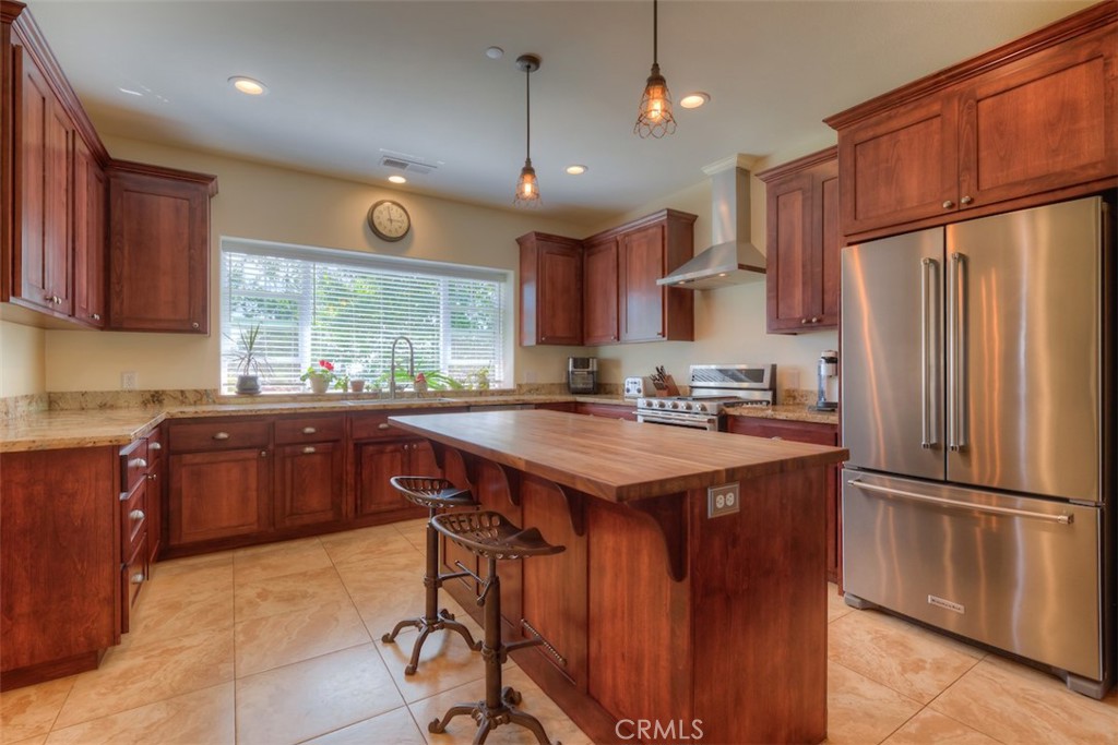 95 Sutter Road Paradise, CA 95969 - Photo 10 of 47 a kitchen with granite countertop a refrigerator a stove a sink dishwasher and wooden cabinets with wooden floor