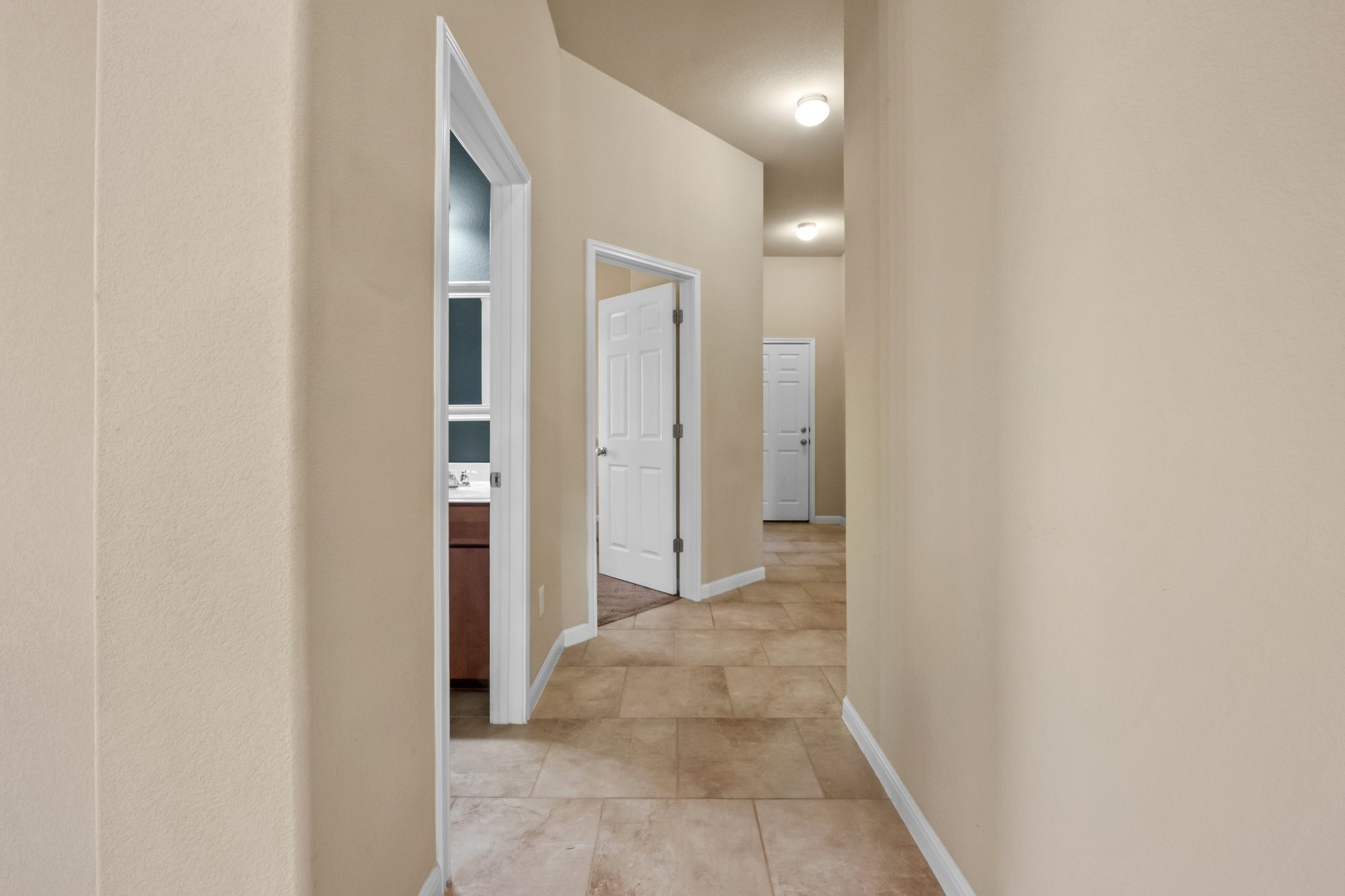 22204 Red Yucca Road Spicewood, TX 78669 - Photo 12 of 34 Hallway featuring baseboards and light tile patterned flooring
