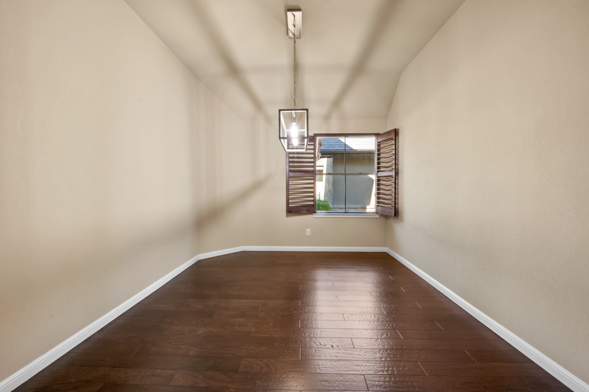 22204 Red Yucca Road Spicewood, TX 78669 - Photo 13 of 34 Unfurnished room featuring dark wood finished floors, a chandelier, and lofted ceiling