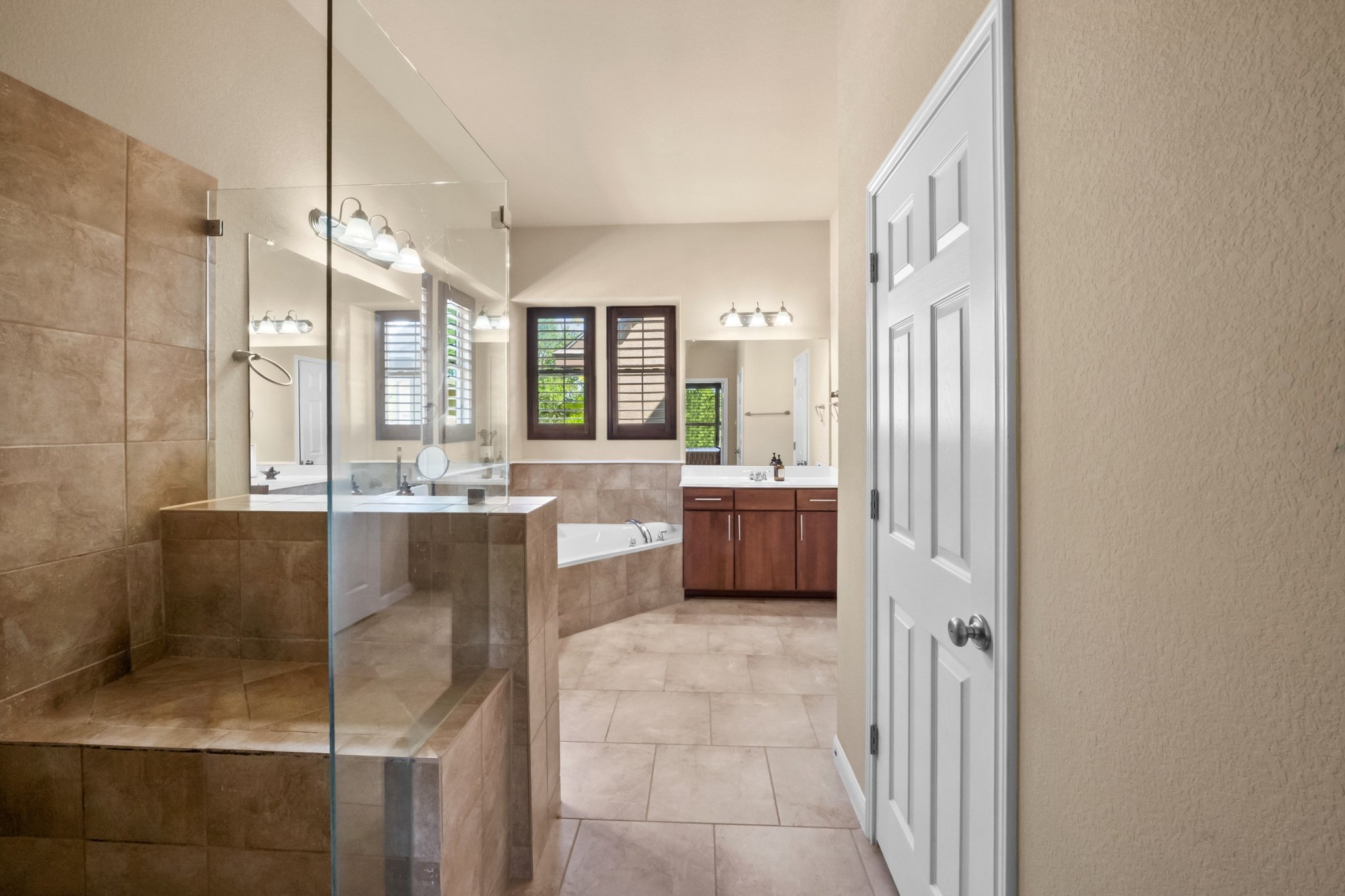 22204 Red Yucca Road Spicewood, TX 78669 - Photo 18 of 34 Bathroom with vanity, a bath, light tile patterned floors, and tiled shower
