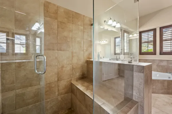 a large bathroom with a glass door shower and sink