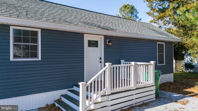 a view of a house with wooden deck and a yard