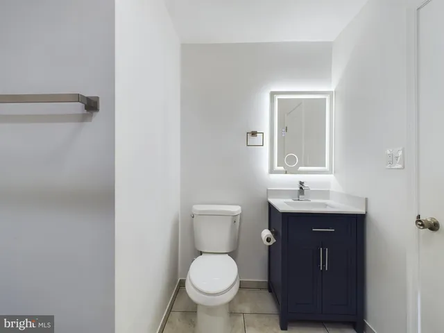a bathroom with a granite countertop toilet sink and mirror
