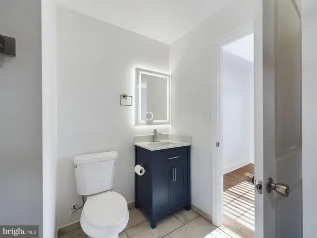a bathroom with a toilet sink vanity and mirror