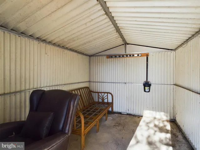 a view of a hallway with wooden floor and furniture