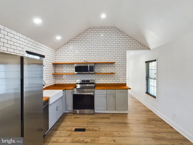 a large kitchen with stainless steel appliances granite countertop a stove and a sink