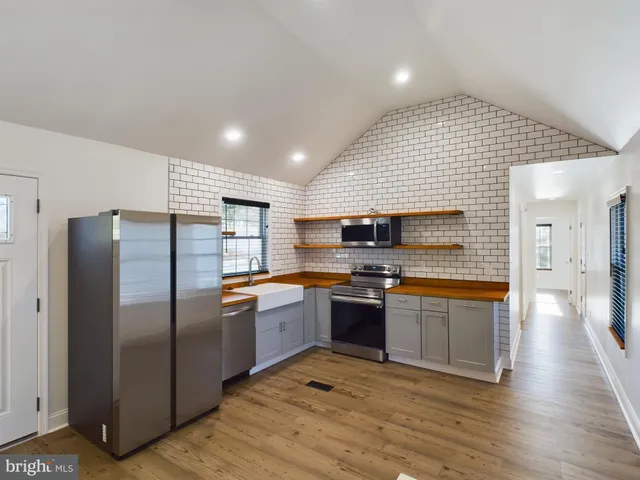 a kitchen with stainless steel appliances granite countertop a refrigerator and a stove top oven