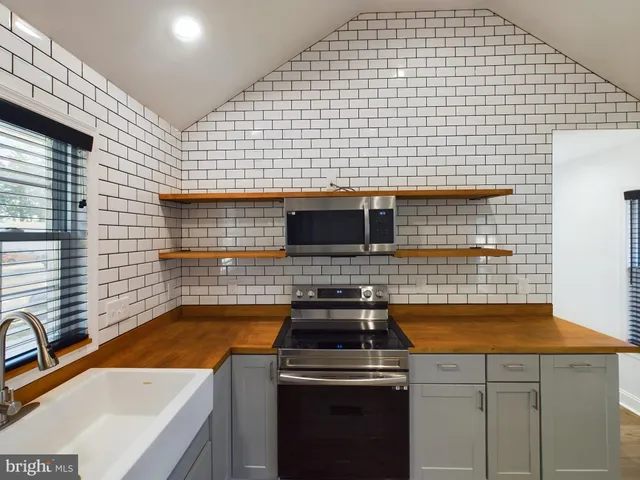 a kitchen with a stove a sink and cabinets