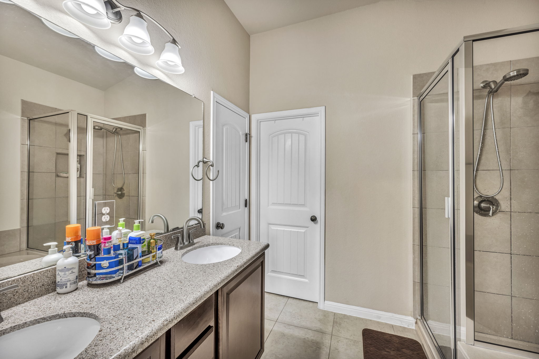 7320 Bandera Ranch Trail, Unit B Austin, TX 78750 - Photo 18 of 27 Primary bathroom featuring double vanity, a shower stall, and light tile patterned floors