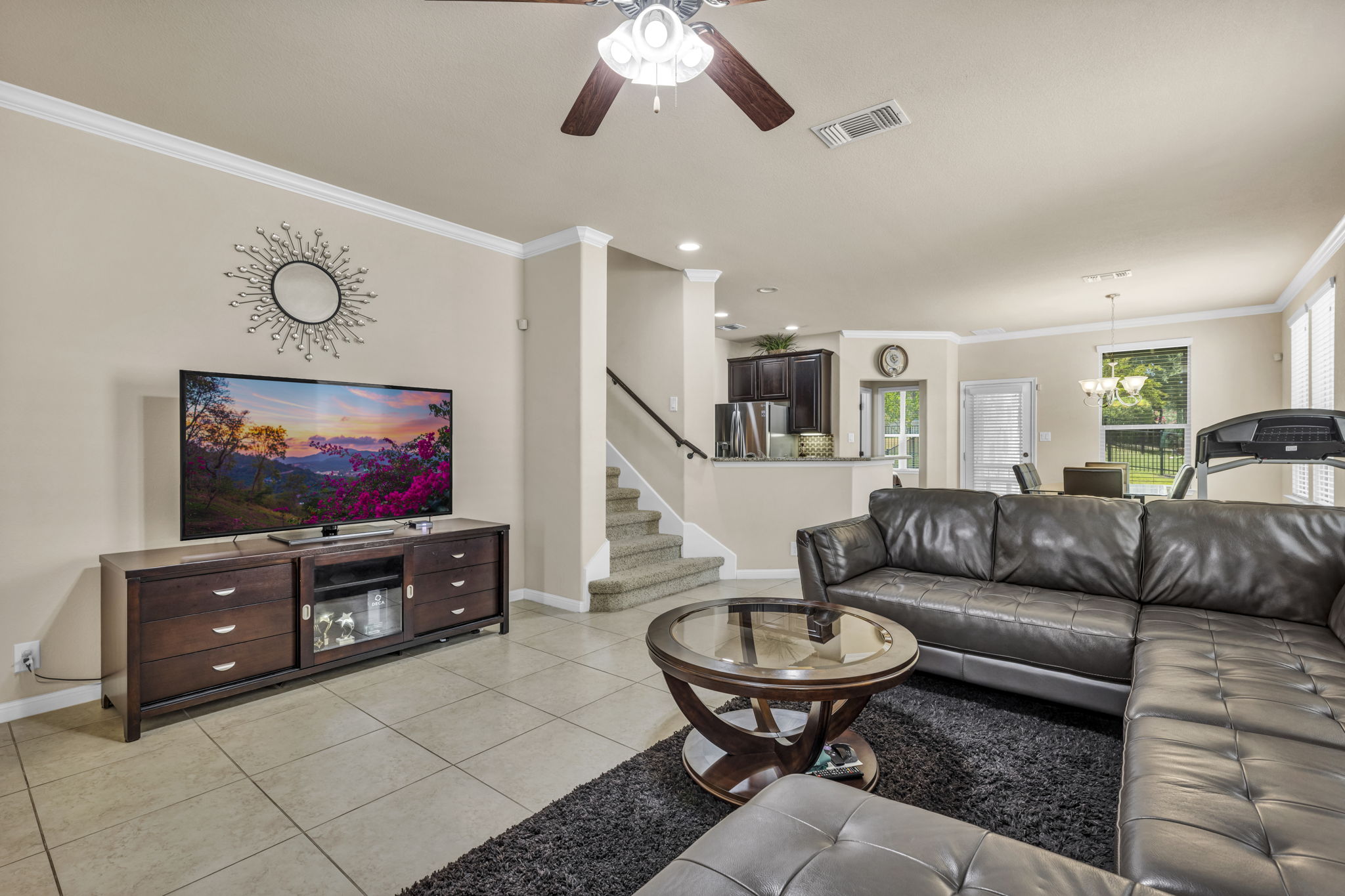 7320 Bandera Ranch Trail, Unit B Austin, TX 78750 - Photo 3 of 27 Living room featuring ceiling fan, ornamental molding, light tile patterned flooring, and a chandelier