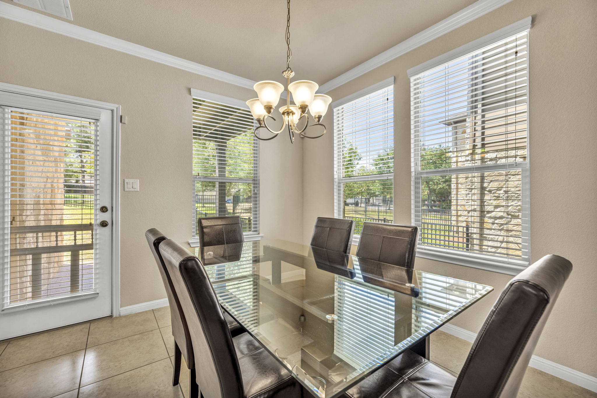 7320 Bandera Ranch Trail, Unit B Austin, TX 78750 - Photo 5 of 27 Dining space featuring crown molding, a chandelier, and light tile patterned floors