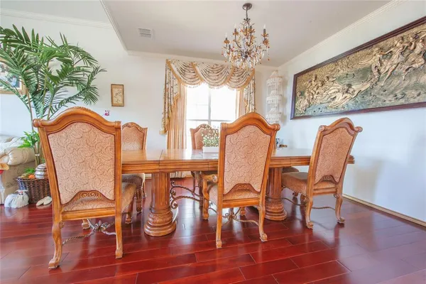 a dining room filled chandelier and wooden floor