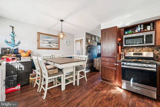 a kitchen with stainless steel appliances a stove a refrigerator and a wooden cabinets