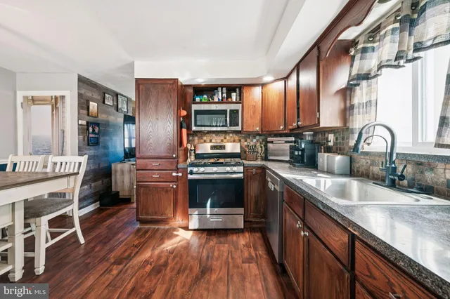 a kitchen with stainless steel appliances granite countertop a stove and a sink