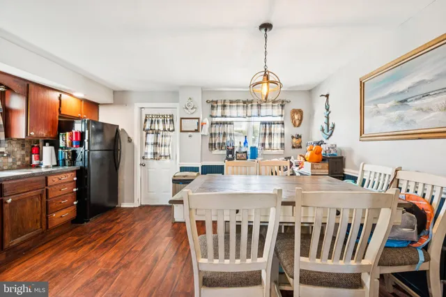 a dining room with furniture a chandelier and wooden floor