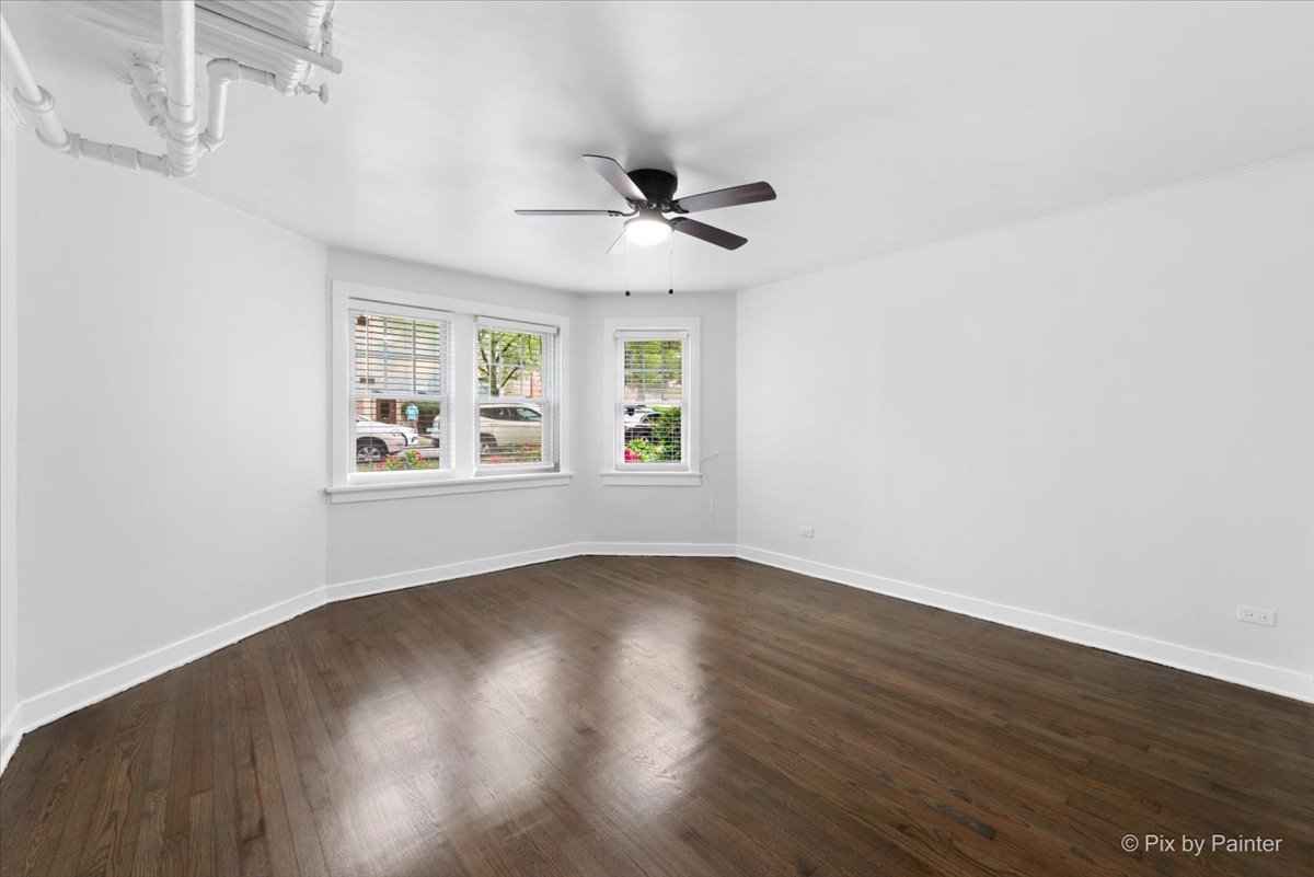 5428 North Campbell Avenue, Unit GS Chicago, IL 60625 - Photo 2 of 14 an empty room with wooden floor ceiling fan and windows