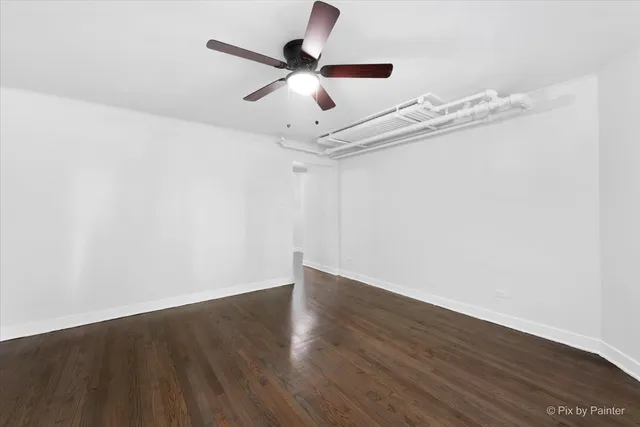 a view of a room with wooden floor and ceiling fan