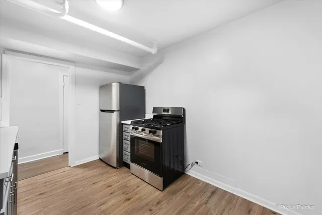 a kitchen with wooden floor and steel stainless steel appliances