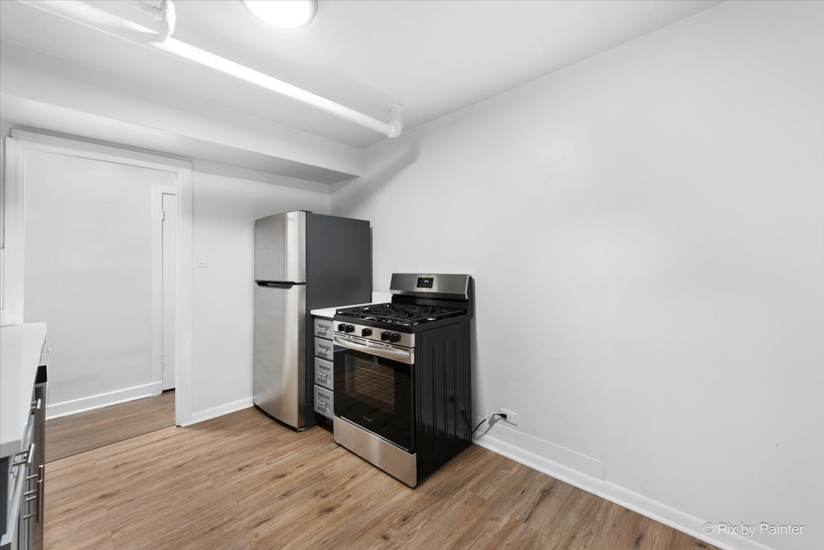 5428 North Campbell Avenue, Unit GS Chicago, IL 60625 - Photo 5 of 14 a kitchen with wooden floor and steel stainless steel appliances