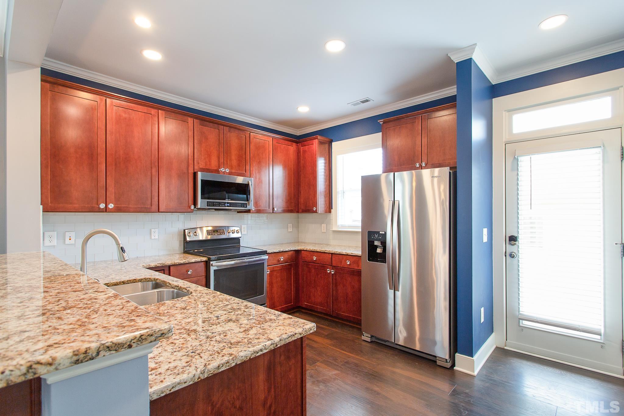 2262 Dunlin Lane Raleigh, NC 27614 - Photo 14 of 27 a kitchen with stainless steel appliances granite countertop a refrigerator a sink dishwasher a stove and white cabinets with wooden floor