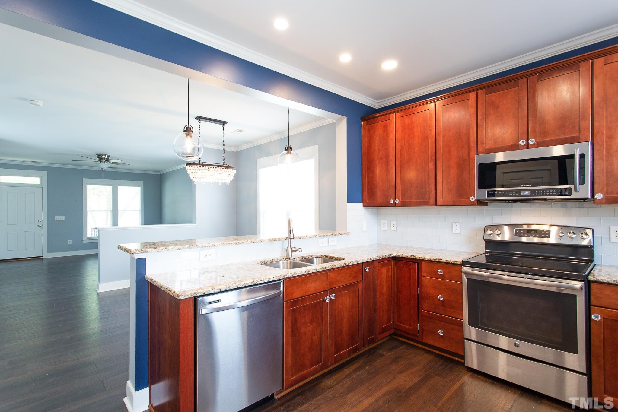 2262 Dunlin Lane Raleigh, NC 27614 - Photo 15 of 27 a kitchen with granite countertop stainless steel appliances a stove sink microwave and cabinets