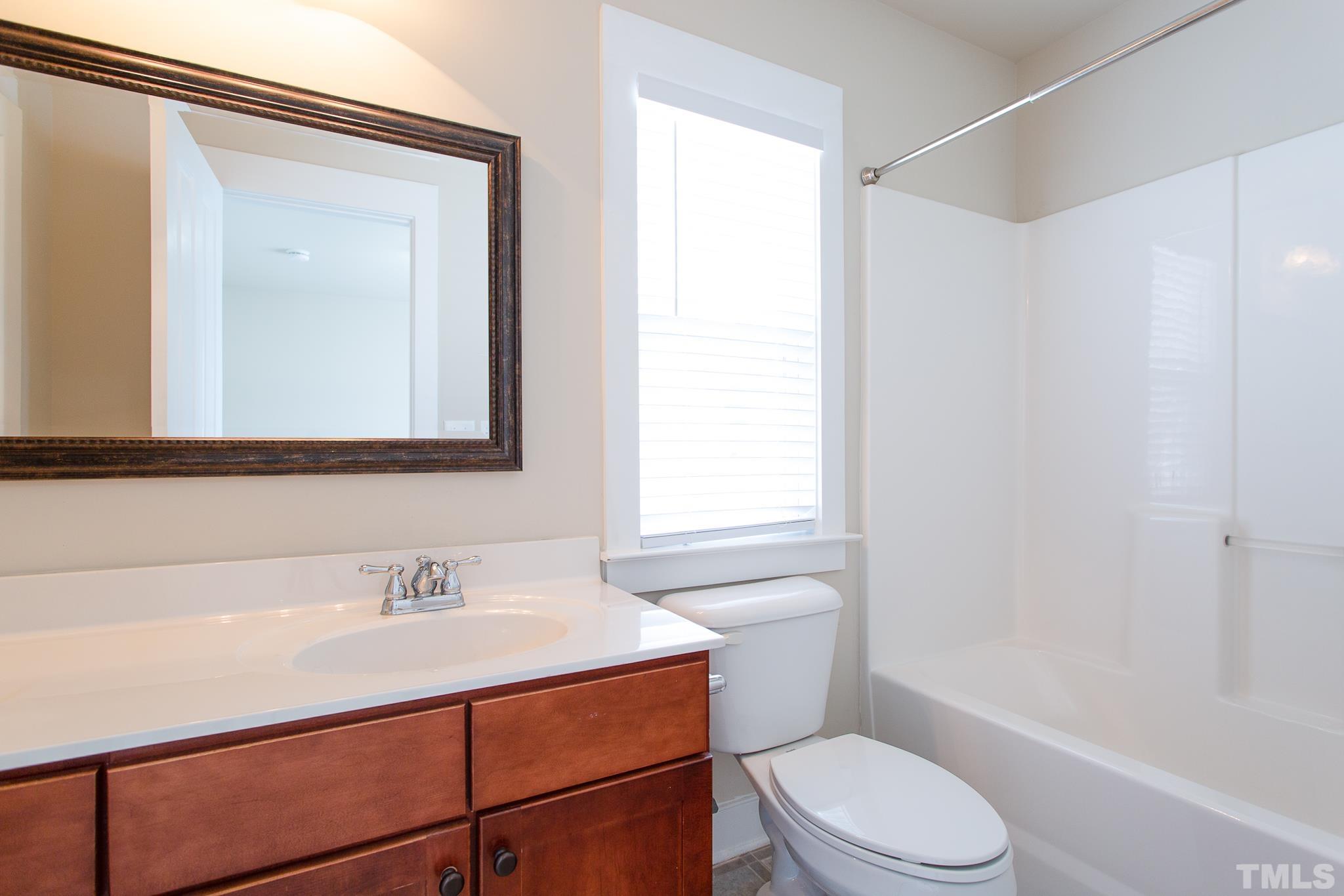 2262 Dunlin Lane Raleigh, NC 27614 - Photo 21 of 27 a bathroom with a sink a mirror and a toilet