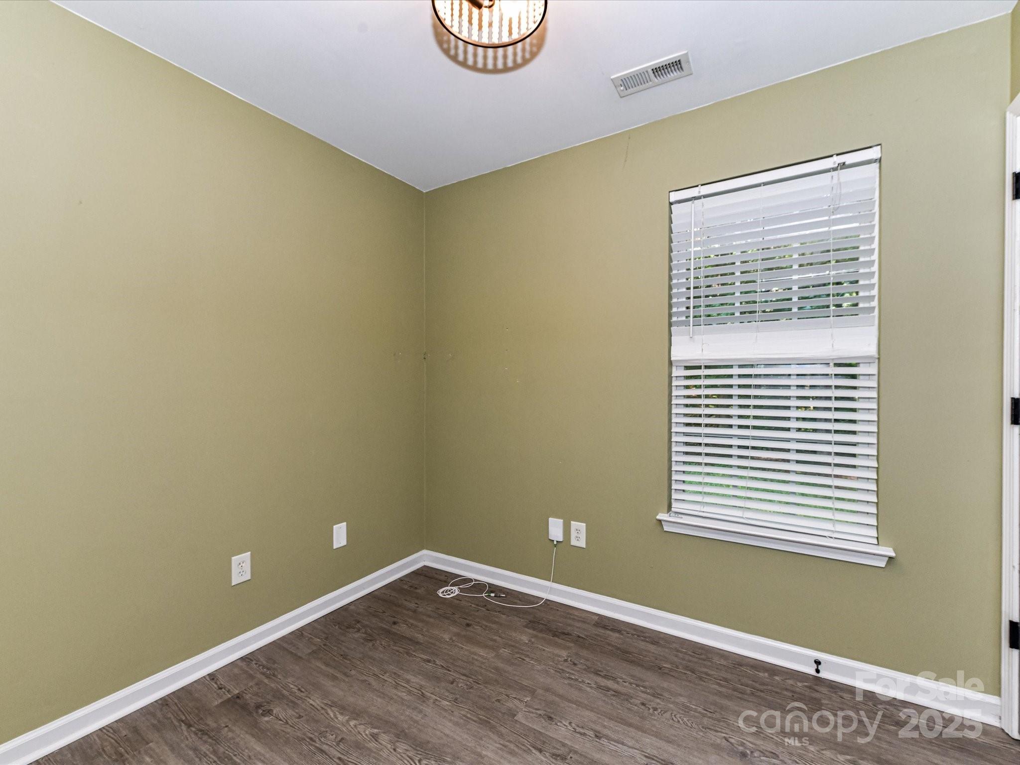12224 Lullingstone Road Pineville, NC 28134 - Photo 15 of 26 a view of an empty room with wooden floor and a window